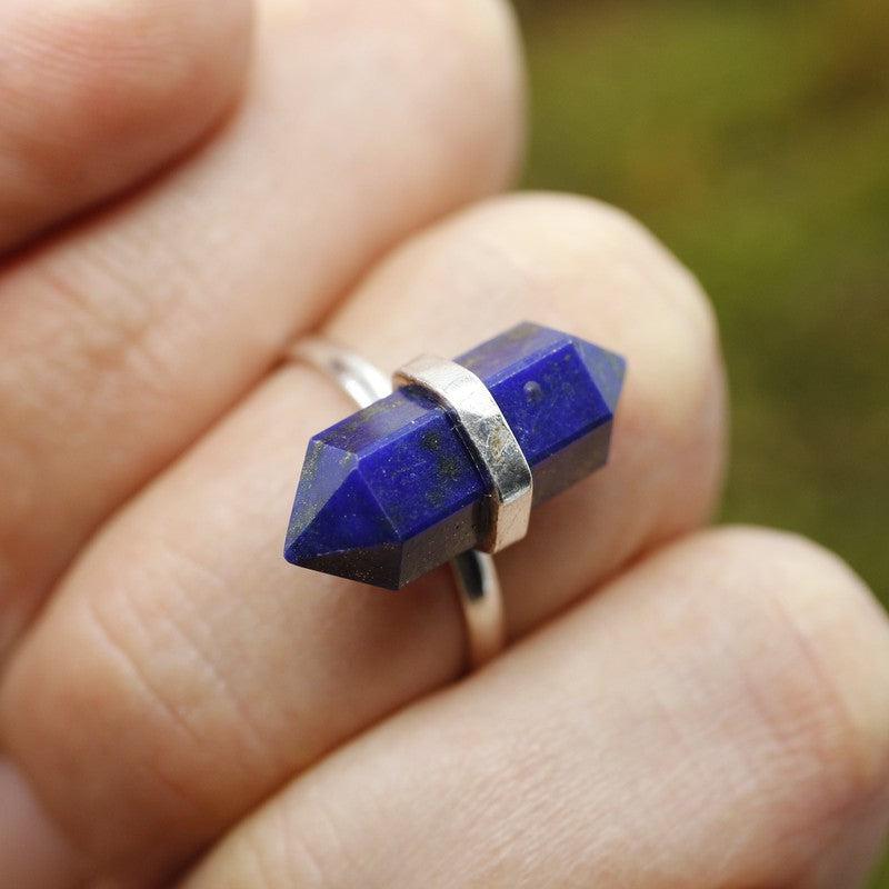 Lapis Lazuli ring on a hand with greenery in the background